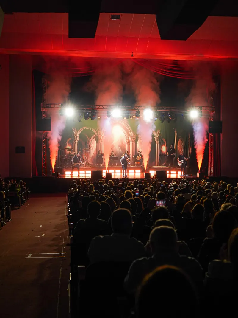 Jatos de fumaça e luz vermelha sobre o palco durante o show